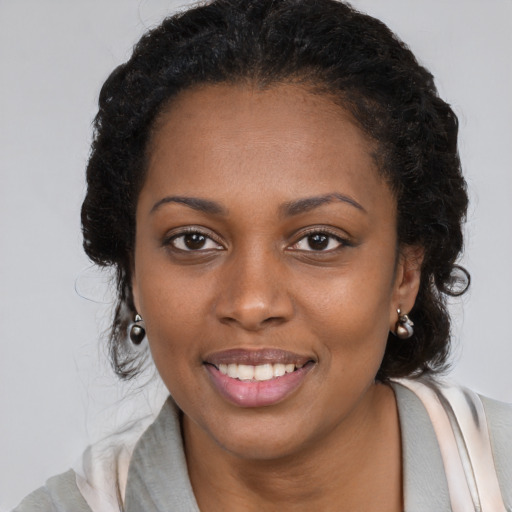 Joyful black young-adult female with medium  brown hair and brown eyes