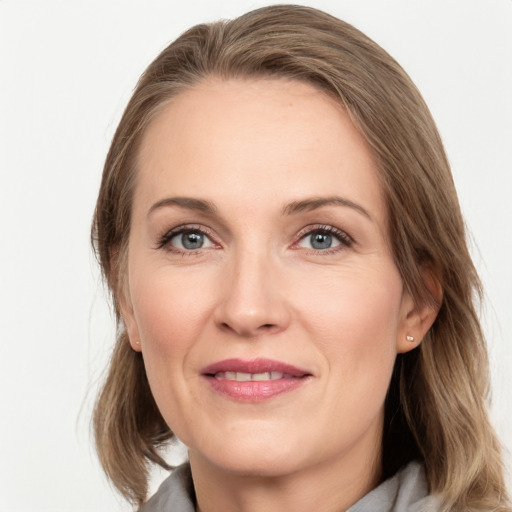 Joyful white adult female with medium  brown hair and grey eyes