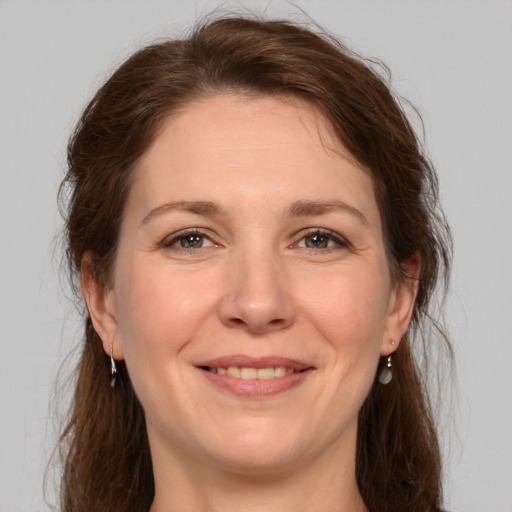 Joyful white adult female with medium  brown hair and grey eyes