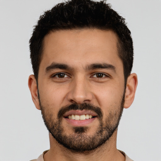 Joyful latino young-adult male with short  brown hair and brown eyes