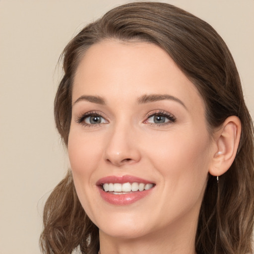 Joyful white young-adult female with medium  brown hair and grey eyes