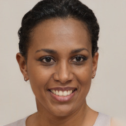 Joyful black young-adult female with short  black hair and brown eyes