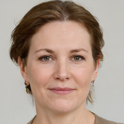 Joyful white adult female with medium  brown hair and grey eyes