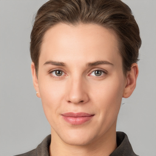 Joyful white young-adult female with short  brown hair and grey eyes