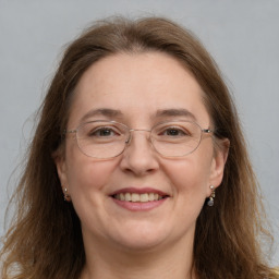 Joyful white adult female with long  brown hair and grey eyes