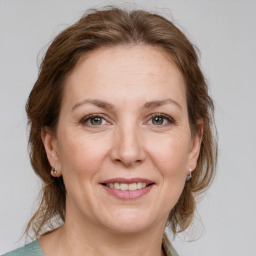 Joyful white adult female with medium  brown hair and grey eyes