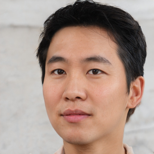 Joyful asian young-adult male with short  black hair and brown eyes