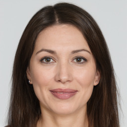 Joyful white adult female with long  brown hair and brown eyes