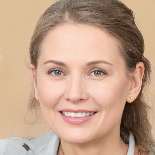 Joyful white young-adult female with medium  brown hair and grey eyes