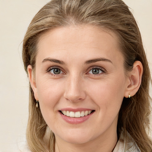 Joyful white young-adult female with long  brown hair and blue eyes