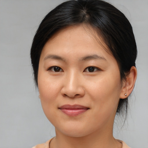 Joyful asian young-adult female with medium  brown hair and brown eyes