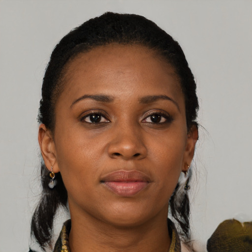 Joyful black adult female with medium  brown hair and brown eyes