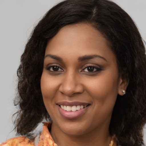 Joyful black young-adult female with medium  brown hair and brown eyes