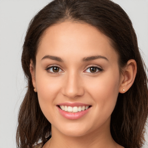 Joyful white young-adult female with long  brown hair and brown eyes