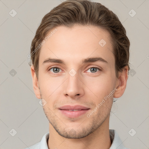 Joyful white young-adult male with short  brown hair and grey eyes