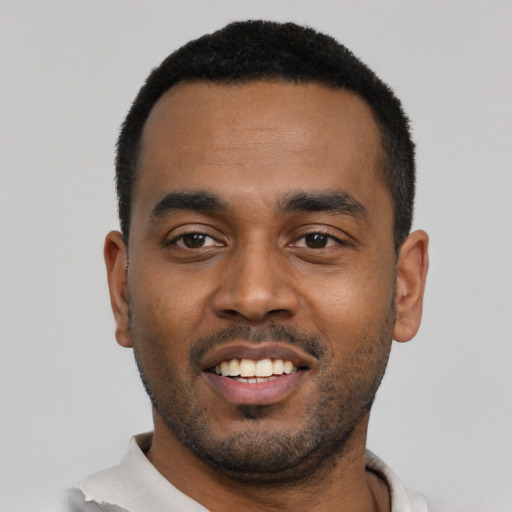 Joyful black young-adult male with short  black hair and brown eyes