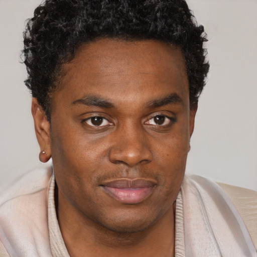 Joyful black young-adult male with short  brown hair and brown eyes