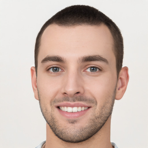 Joyful white young-adult male with short  brown hair and brown eyes