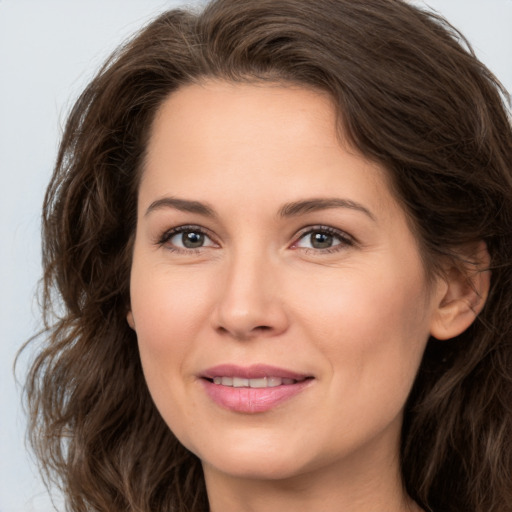 Joyful white adult female with long  brown hair and brown eyes