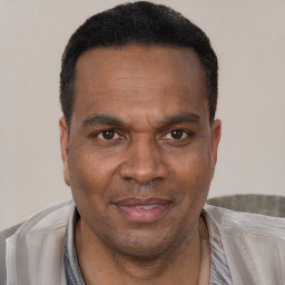 Joyful black adult male with short  black hair and brown eyes