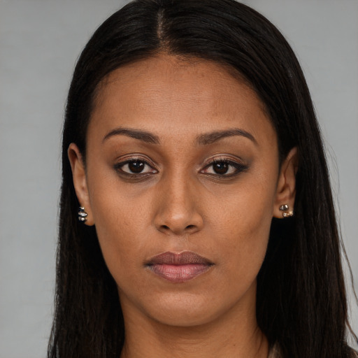 Joyful black young-adult female with long  brown hair and brown eyes