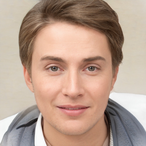 Joyful white young-adult male with short  brown hair and grey eyes