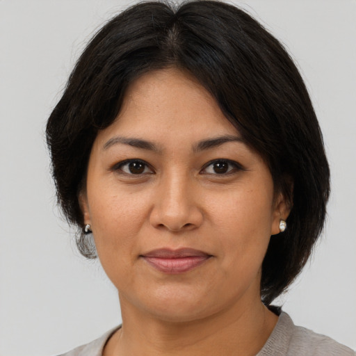 Joyful latino adult female with medium  brown hair and brown eyes
