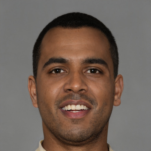 Joyful black young-adult male with short  brown hair and brown eyes