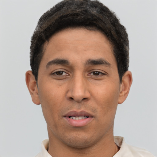 Joyful latino young-adult male with short  brown hair and brown eyes