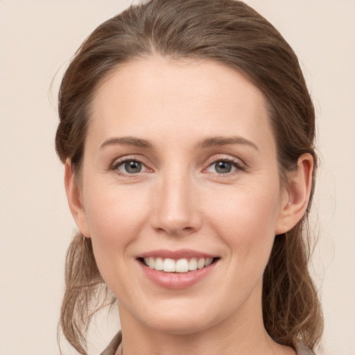 Joyful white young-adult female with medium  brown hair and grey eyes