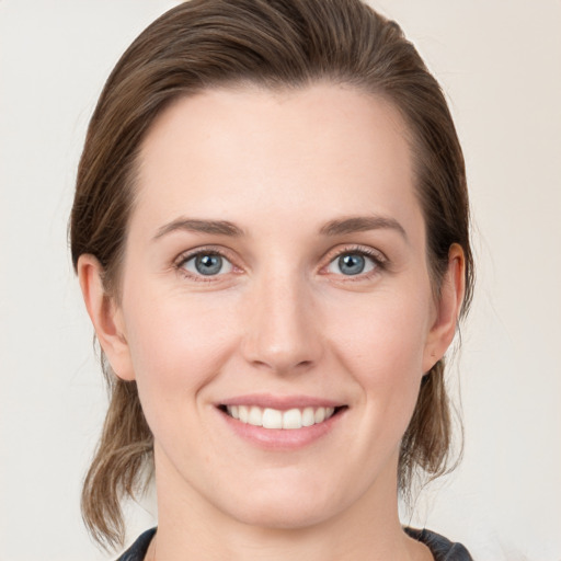 Joyful white young-adult female with medium  brown hair and blue eyes