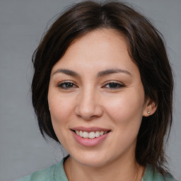 Joyful asian young-adult female with medium  brown hair and brown eyes