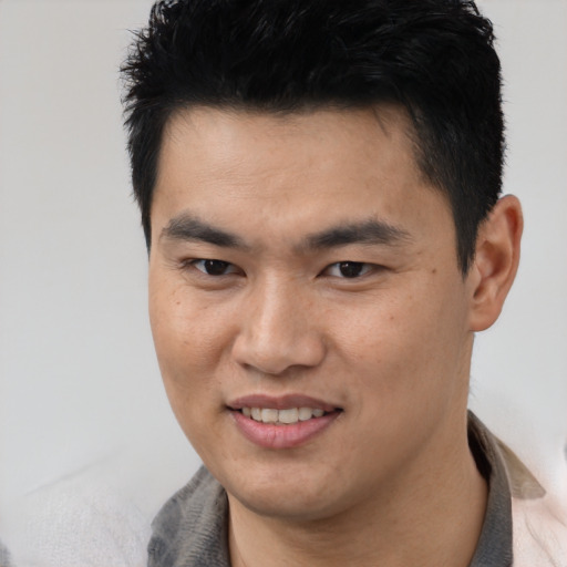 Joyful asian young-adult male with short  brown hair and brown eyes