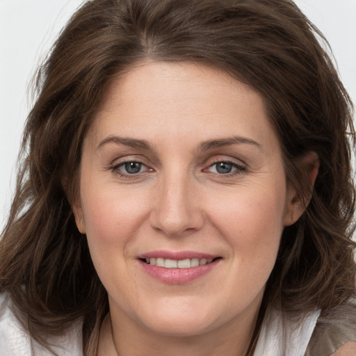 Joyful white young-adult female with long  brown hair and grey eyes