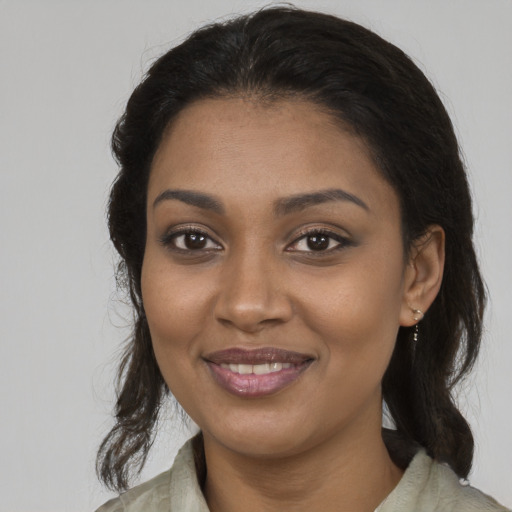 Joyful black young-adult female with medium  brown hair and brown eyes