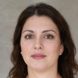 Joyful white adult female with long  brown hair and brown eyes