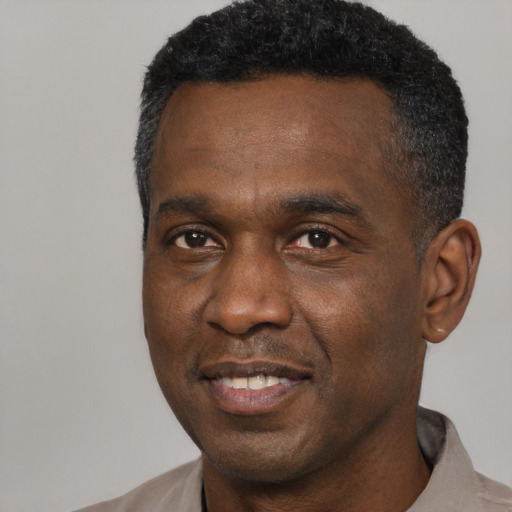 Joyful black adult male with short  black hair and brown eyes