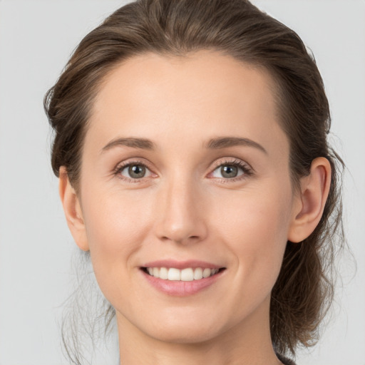 Joyful white young-adult female with medium  brown hair and grey eyes