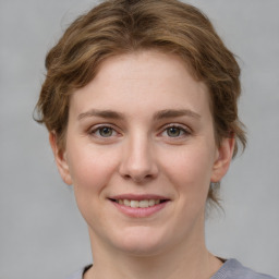 Joyful white young-adult female with medium  brown hair and grey eyes