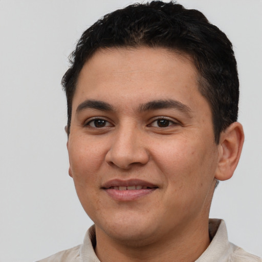 Joyful latino young-adult male with short  brown hair and brown eyes