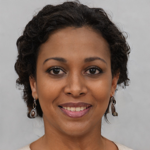 Joyful black young-adult female with medium  brown hair and brown eyes