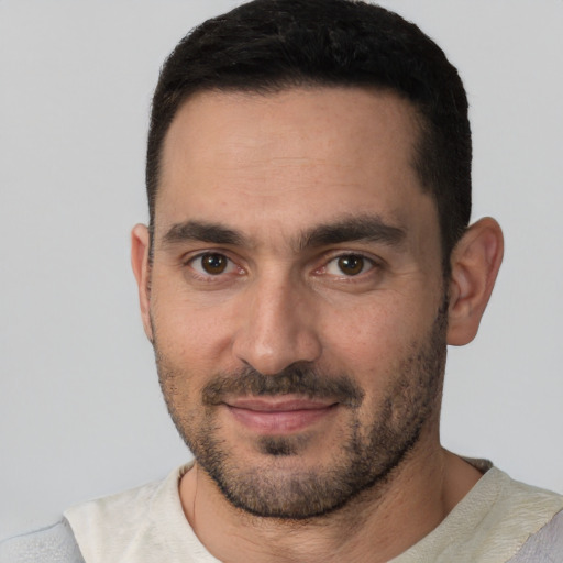 Joyful white young-adult male with short  black hair and brown eyes