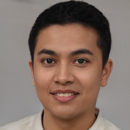 Joyful latino young-adult male with short  black hair and brown eyes