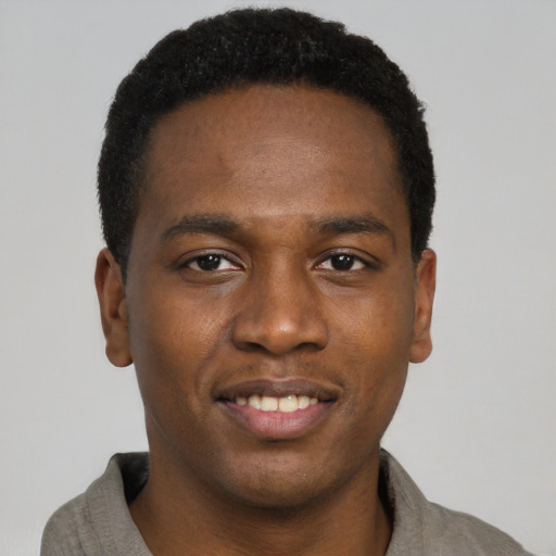 Joyful black young-adult male with short  black hair and brown eyes