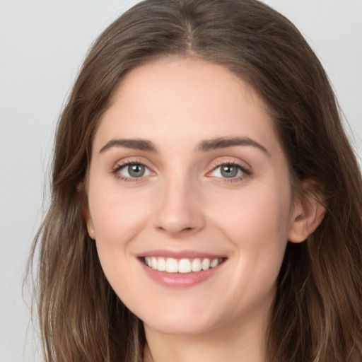 Joyful white young-adult female with long  brown hair and green eyes