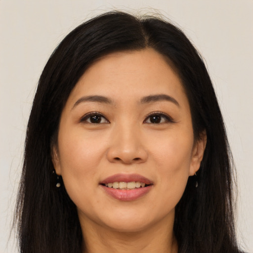 Joyful asian young-adult female with long  brown hair and brown eyes