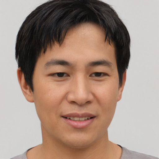 Joyful asian young-adult male with short  brown hair and brown eyes