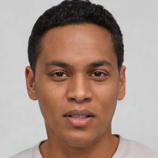 Joyful black young-adult male with short  black hair and brown eyes
