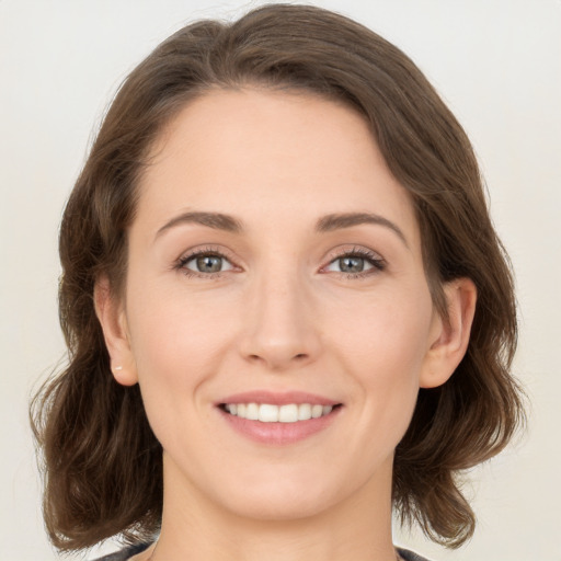 Joyful white young-adult female with medium  brown hair and green eyes