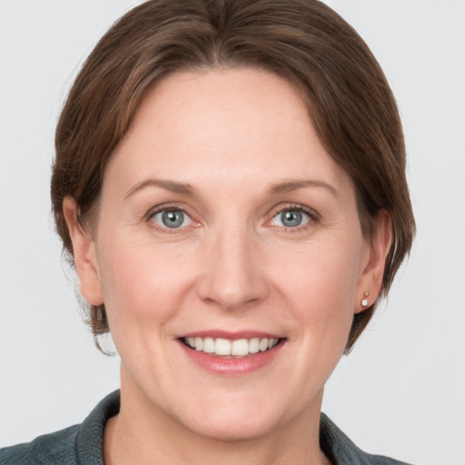 Joyful white adult female with medium  brown hair and grey eyes